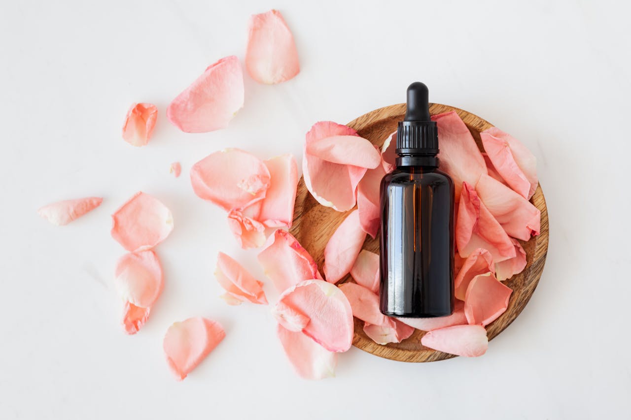 Crafting Captivating Headlines: Your awesome post title goes here Top view of empty brown bottle for skin care product placed on wooden plate with fresh pink rose petals on white background isolated
